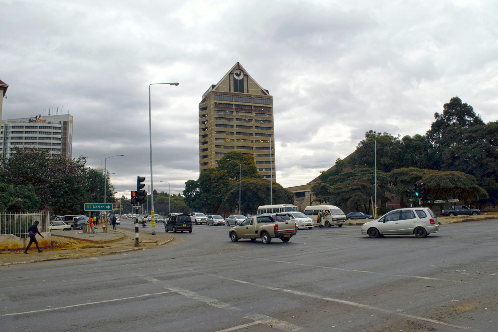 Busy Harare street with traffic passing between city buildings